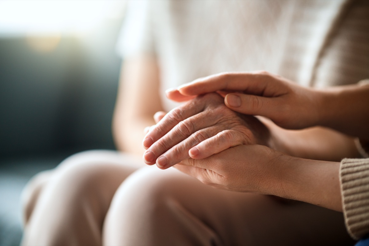 A supportive hand resting on another person's hands